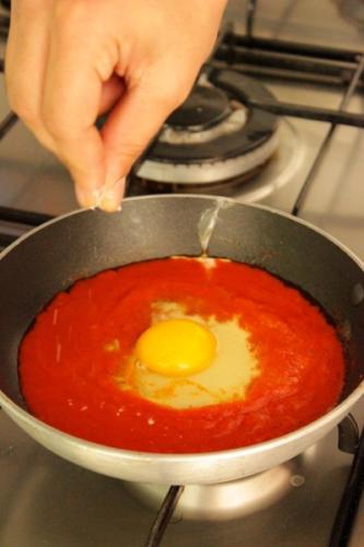 aggiungete un pizzico di sale e fate scivolare l'uovo al sugo nel piatto
